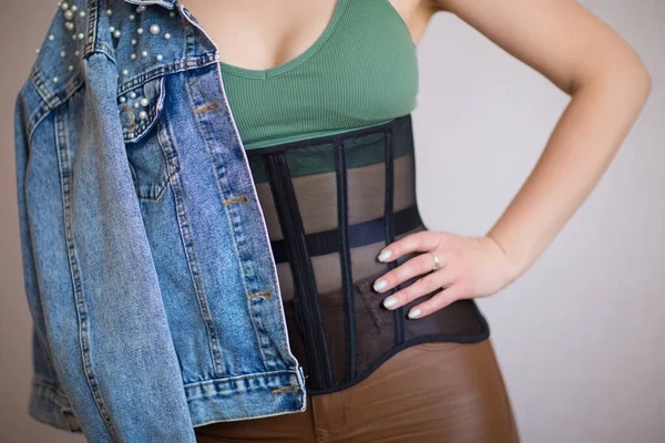 Yeşil bluzlu kız, korse, deri pantolon ve kot ceket.