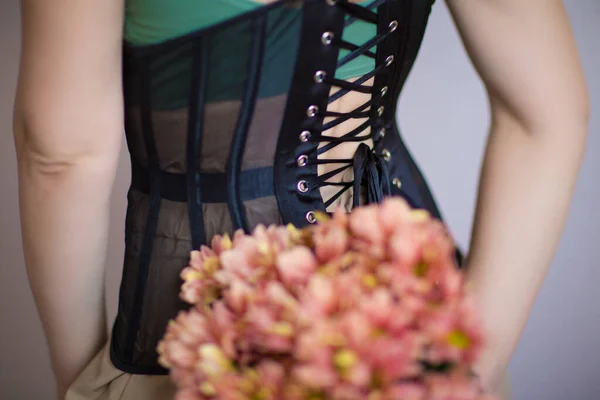 Yeşil bluzlu kız, elinde çiçekleri tutan korse.