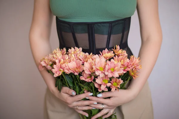 Yeşil bluzlu kız, elinde çiçekleri tutan korse.