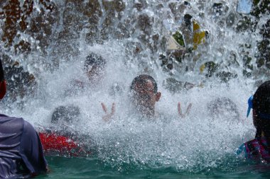 Tanggerang, Endonezya - 11 19 2020: aşağıdan yüzen insanların üzerine düşen su damlası heyecanla beklenen an.