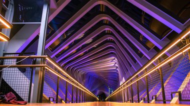 Senayan şehrinde insanlar renkli neon ışıklarla kaplı yaya köprüsü.