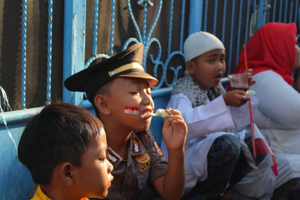 Jakarta, Endonezya - 08 18 2019: Küçük çocuklar, Endonezya 'nın 73. bağımsızlık gününü kutladıktan sonra atıştırmalık yerken dinleniyorlar.