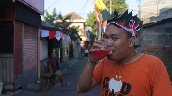 印度尼西亚雅加达 2019年8月18日 一名男子在参加了庆祝印度尼西亚第73个独立日的游行后口渴并喝了一杯果汁 — 图库照片