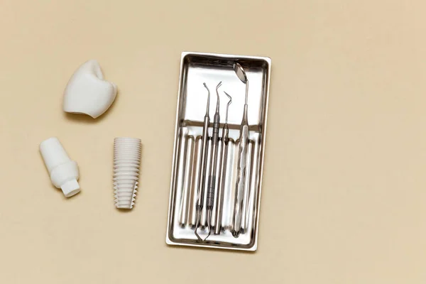 歯のインプラント ベージュ地の歯のツール 人工歯の歯科インプラントモデル 歯科医療器具の概念 テキストとデザインのための場所と写真 — ストック写真