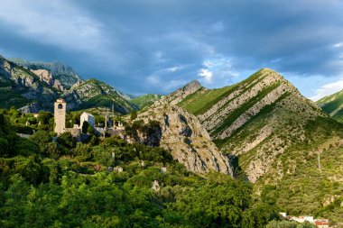 Eski kale, Karadağ 'ın Bar kentindeki dağların arka planında saat kulesi