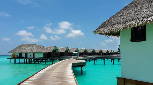 Overwater bungalows and luxury villas in the blue lagoon, on the white sandy beach of Bora Bora island, Maldives, Tahiti.