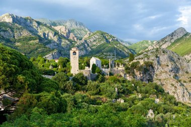 Eski kale, Karadağ 'ın Bar kentindeki dağların arka planında saat kulesi