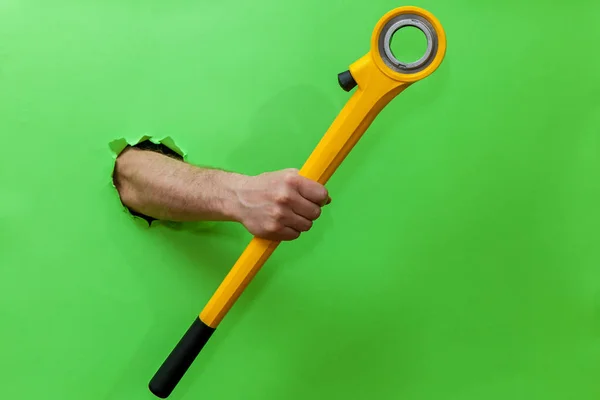 Man Holds Hand Tool Fixing Plumbing Green Background — ストック写真
