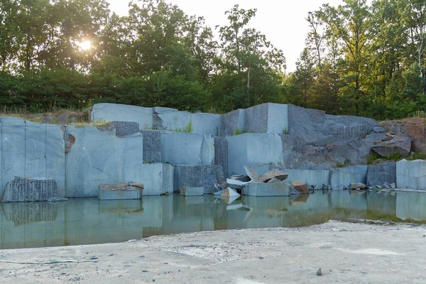 Granite quarry with large granite blocks Abandoned granite quarry with rain water. Granite mining in a quarry.