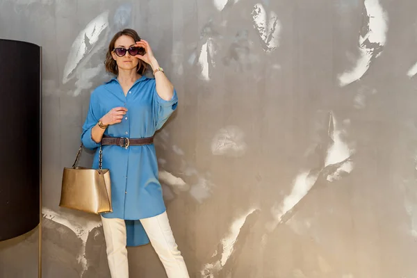 Модная Стильная Девушка Позирует Белых Брюках Голубой Рубашке Солнцезащитных Очках — стоковое фото
