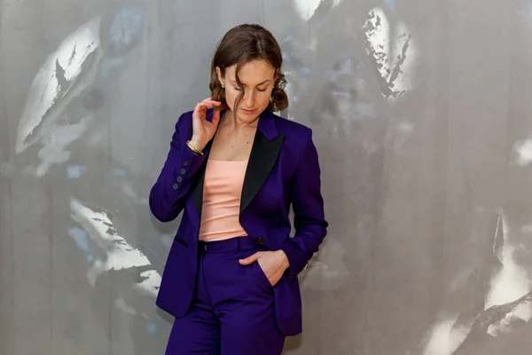 Модная Стильная Девушка Позирует Фиолетовых Брюках Фиолетовой Куртке Серой Стене — стоковое фото