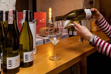 Ukraine, Kyiv 27 December 2019 : Bottles with French wine UBY CUB on the table and Samellier pours wine into a glass
