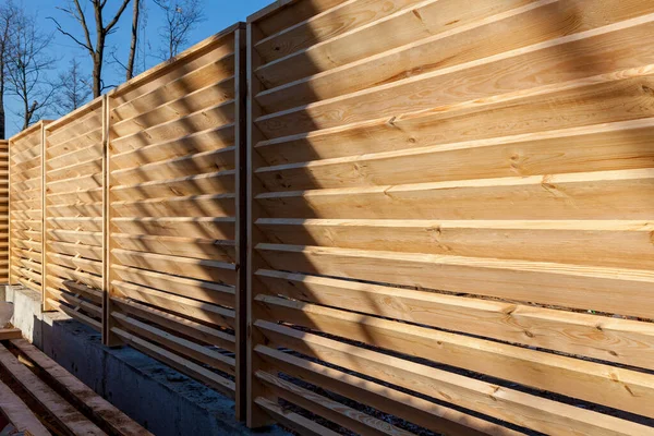 Installation of a horizontal wooden fence around the house and land