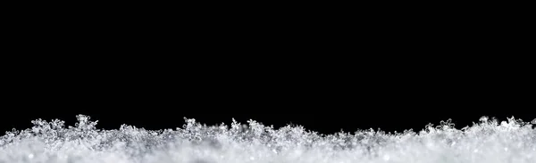 雪のフレークを閉じ 上にテキストのためのスペースと黒の背景に隔離された自然な雪のテクスチャ ホリデーギフトカード用のテンプレート 雪のマクロな質感 大きなサイズ — ストック写真