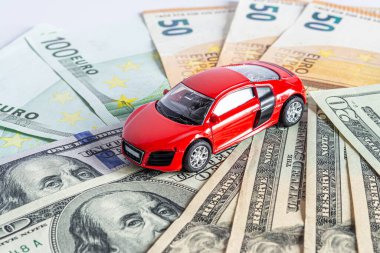 Güzel bir spor arabanın modeli dolar ve avro banknotlarının üzerinde duruyor..