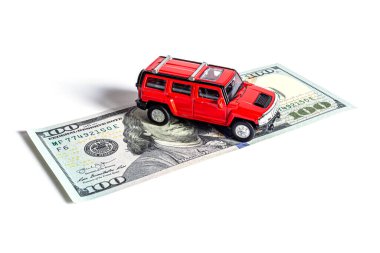 Güzel bir arabanın yakın plan modeli beyaz arka planda izole edilmiş 100 Amerikan doları üzerinde duruyor..