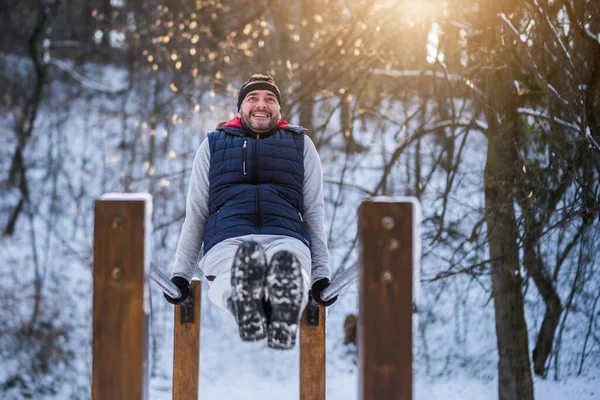 大人の男は冬に公園のプッシュアップバーで行使しています — ストック写真