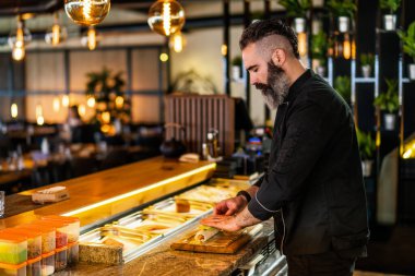 Suşi şefi suşi restoranında suşi hazırlıyor..