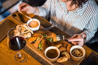 Restoranda yemek yiyip şarap içen yetişkin bir kadına yakın durun..