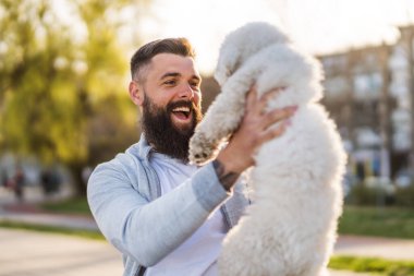 Adult man is enjoying sunny day with his dog.