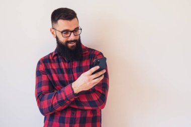 Akıllı telefon kullanan mutlu bir adamın portresi. Metnin ya da ilanın için resim üzerine boşluk kopyala.