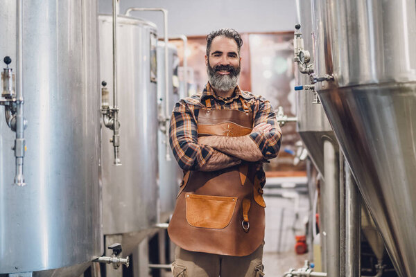 Portrait of man who is working at craft beer factory. Small family business, production of craft beer.