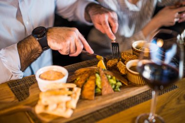 Lokantada yemek yiyen yetişkin bir adama yaklaş..