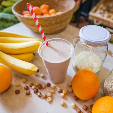 Healthy protein shake on table with fruits and vegetables ingredients around.