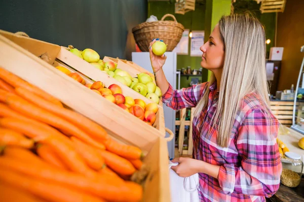 Woman buying goods in fruits and vegetables shop.