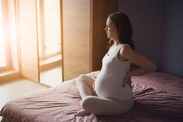 Zwangere Vrouw Heeft Pijn Haar Buik Rug Zit Thuis Bed — Stockfoto