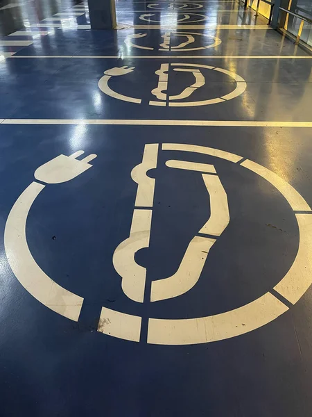 Mavi taşralı üzerinde elektrikli araba sembolü olan birkaç otopark.