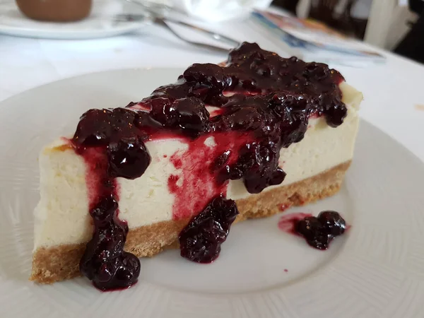 Kırmızı böğürtlenli lezzetli bir cheesecake diliminin yakın çekimi.