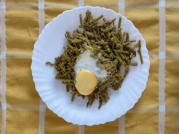 Üzerinde yumurta olan bir tabak yaban kuşkonmaz manzarası.
