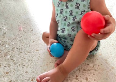 Kırmızı ve mavi plastik toplarla oynayan bebeğin yakın çekimi