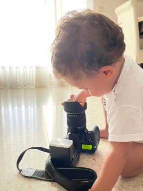 Little boy with SLR camera on the floor