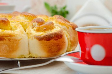 Bir dilim limonlu turta ve kırmızı tabakta bir fincan çay.