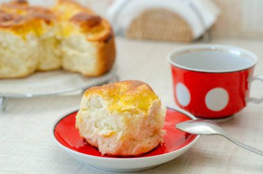 Bir dilim limonlu turta ve kırmızı tabakta bir fincan çay.