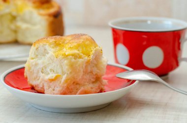 Bir dilim limonlu turta ve kırmızı tabakta bir fincan çay.