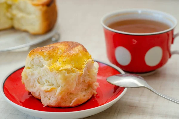 cup of tea with a slice of lemon pie and a saucer on a red plate