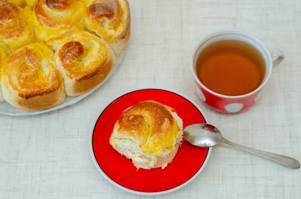 cup of tea with a slice of lemon pie and a saucer on a red plate