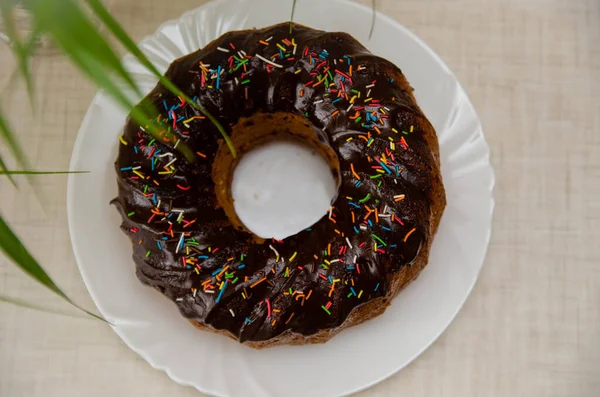 Round cupcake with chocolate torring on the white plate