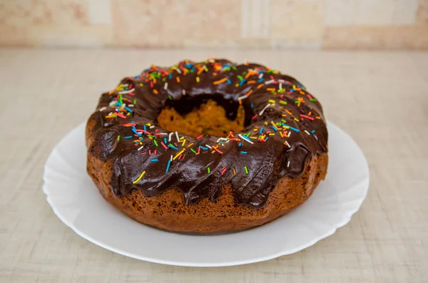 Round cupcake with chocolate torring on the white plate