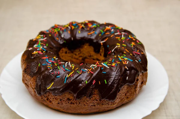Round cupcake with chocolate torring on the white plate