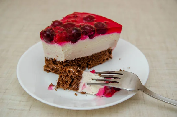 slice of red velvet cake with fresh berries on a dark background.