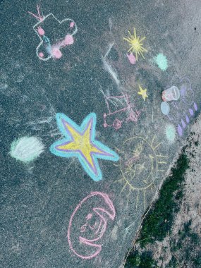 Çocuklar açık havada resim yapıyor. Yoldaki görev resimleri