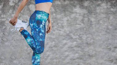 Spor kıyafetleri giymiş, geniş bir fotokopi alanıyla esneme hareketleri yapan panoramik kadın pankartı..