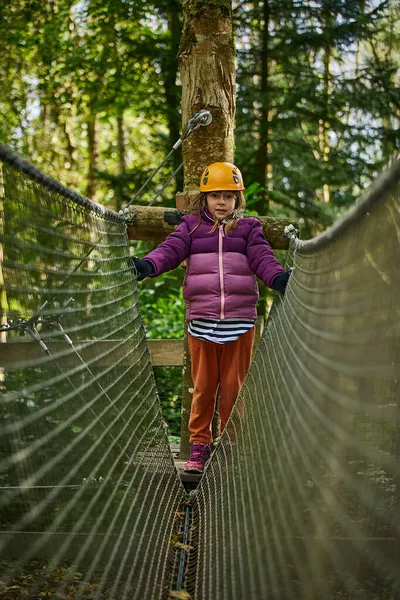 Abenteuer-Hochseilpark - Kinder mit Berghelm und Sicherheitsausrüstung im Parcour — Stockfoto