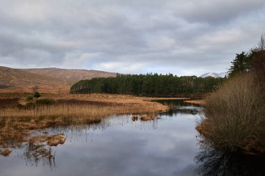 Glenveagh Ulusal Parkı, Donegal Şirketi. Dağlar arasındaki göl manzarası. Bulutlu gökyüzü ile dağ sahnesi.