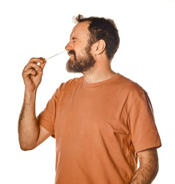 Sakallı adam nahoş bir ifadeyle antijen testi yapıyor. Reklam için beyaz izole edilmiş arka planda. Sınava girerken rahatsız..