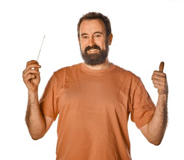 Sakallı adam mutlu ve gülümsüyor çünkü hızlı antijen testi negatif çıktı ve bunu gururla kameraya gösteriyor.